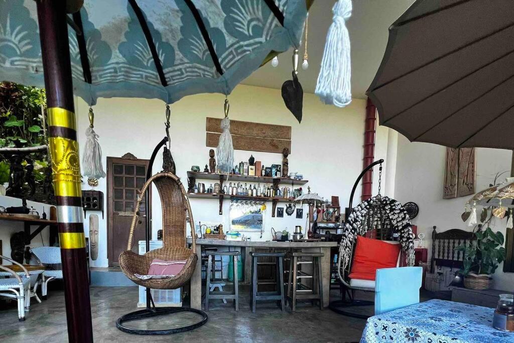 ValenciaASRI Villas的一间设有酒吧、椅子和遮阳伞的房间