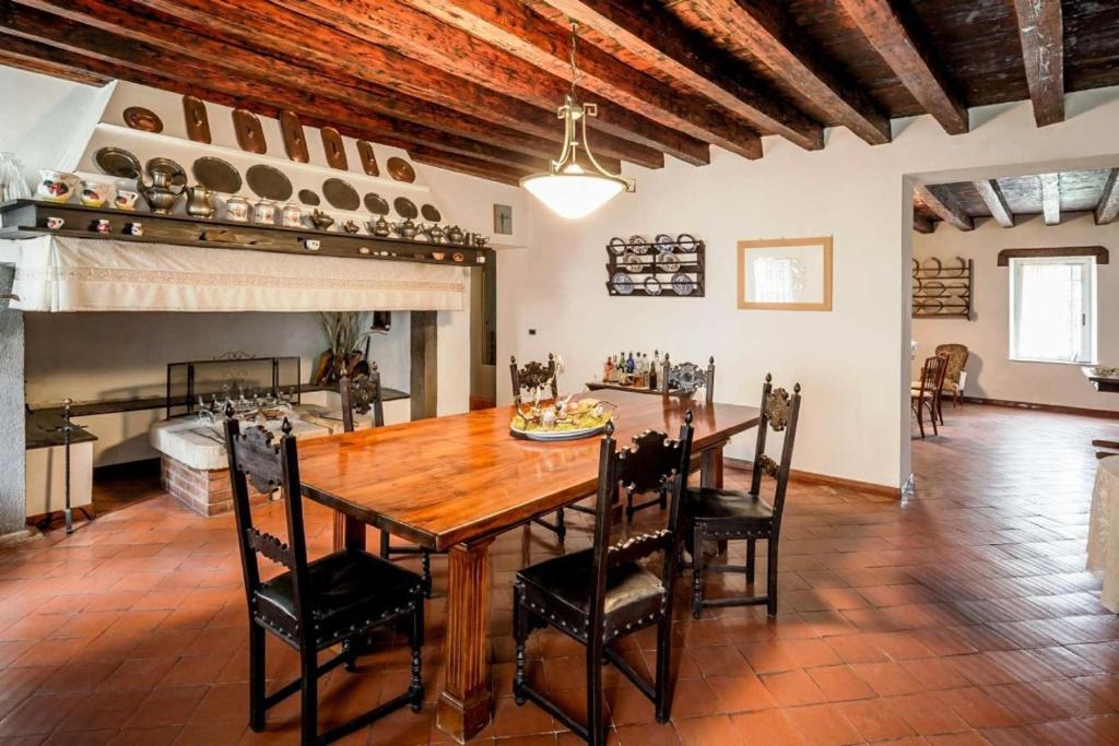 Villa Trigatti Udine Galleriano的一间带木桌和椅子的用餐室