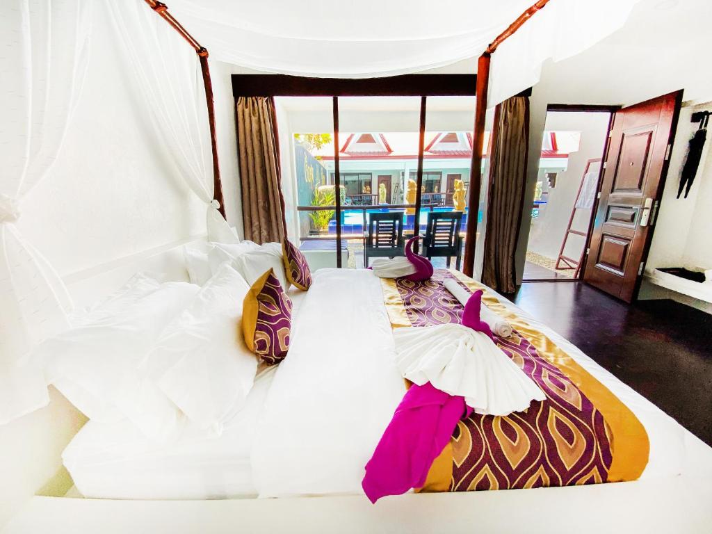公主港Carpe Diem Villas & Resort的卧室配有一张带白色床单和粉红色配件的大床