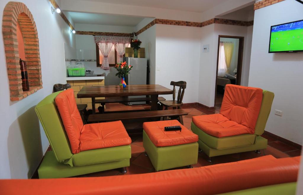 莱瓦镇Apartahotel La Gran Familia的客厅配有桌椅和电视。