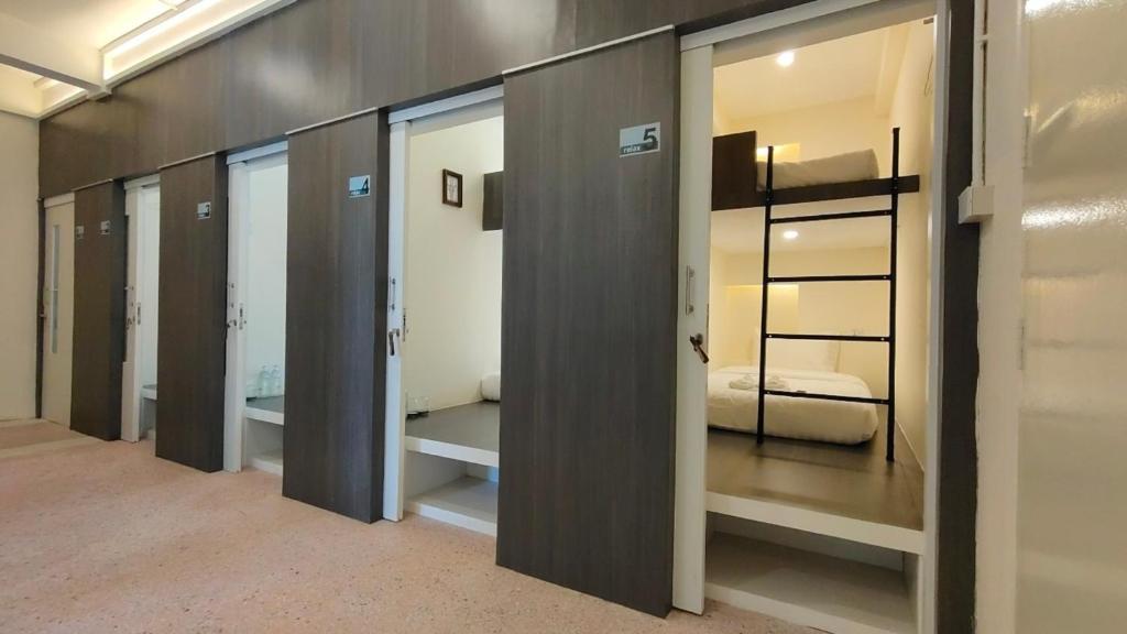 洛坤府Norm Space Hostel NST的一张床的房间里一排玻璃门