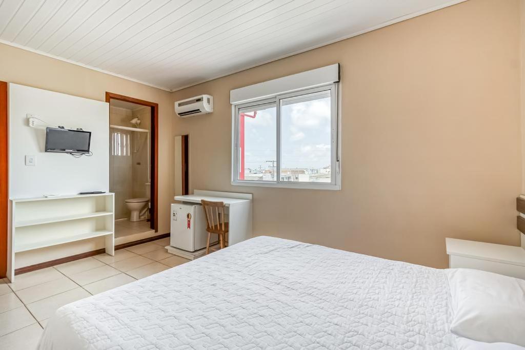 里奥格兰德Hotel Pousada Vento Sul的卧室配有白色的床和窗户。