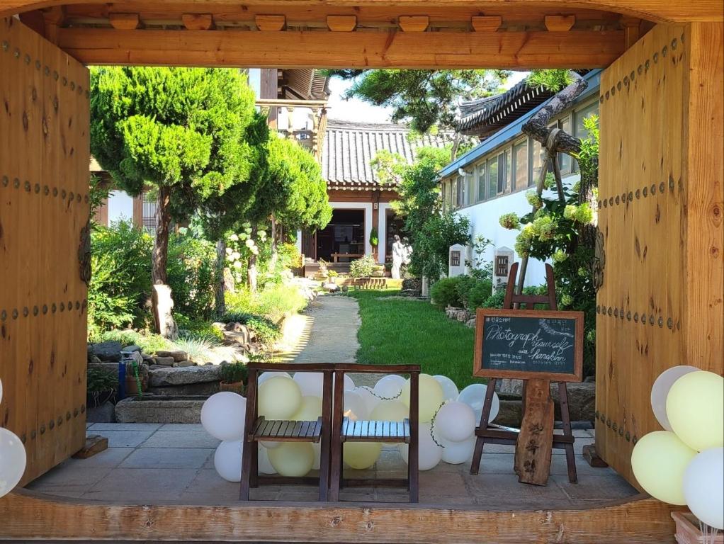 庆州HanokInn的庭院中带椅子和黑板的凉亭