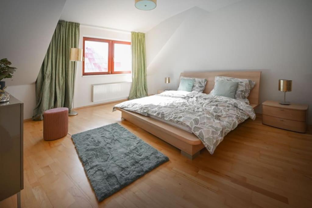 奥洛穆茨V CENTRU dění的一间卧室配有一张带绿色窗帘和地毯的床