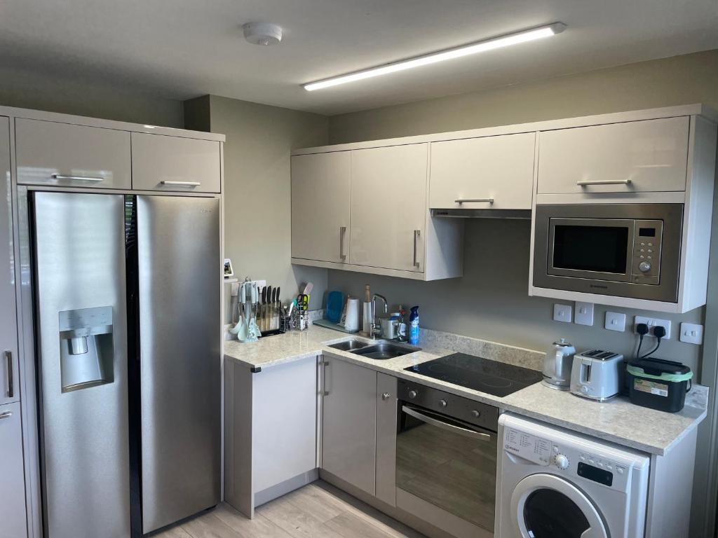 戈尔韦Small,smart,tidy 2 bed apartment的厨房配有不锈钢冰箱和洗碗机