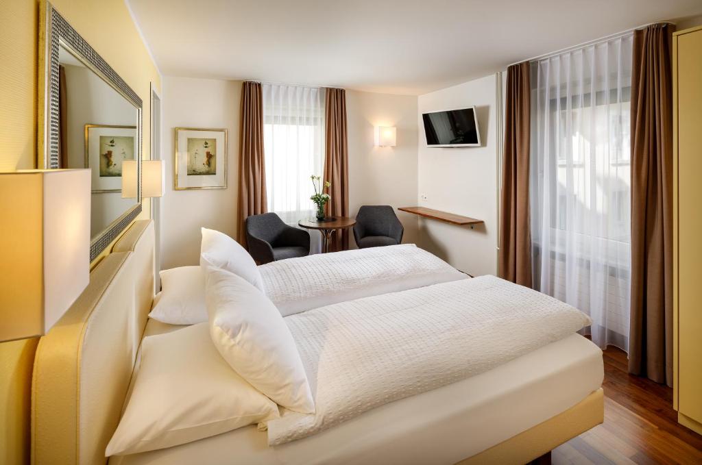 苏黎世施密特家庭酒店的酒店客房配有两张床和一张书桌