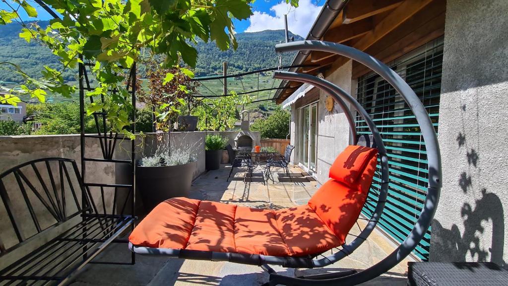 马蒂尼威尔Chez Pewee, beau duplex en ville, parc privé的庭院里摆放着带橙色靠垫的长凳