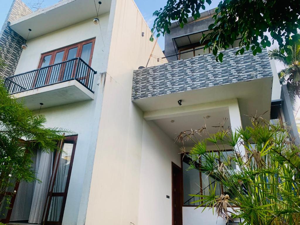 高尔Jungle city Hostel的带阳台和植物的白色房屋