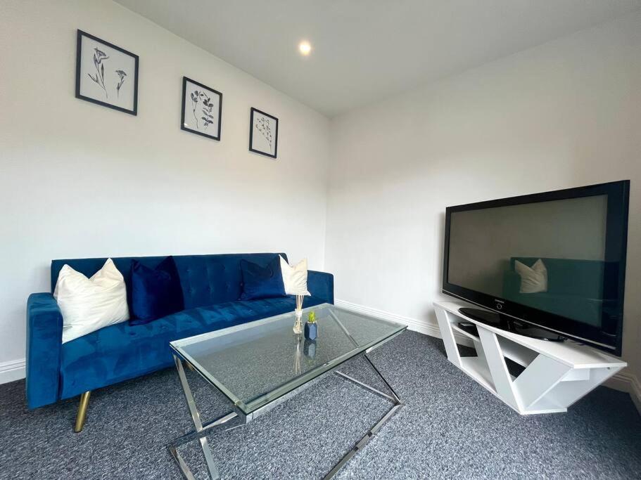 伯恩茅斯Lorne Park Road, Bournemouth的客厅配有蓝色的沙发和电视