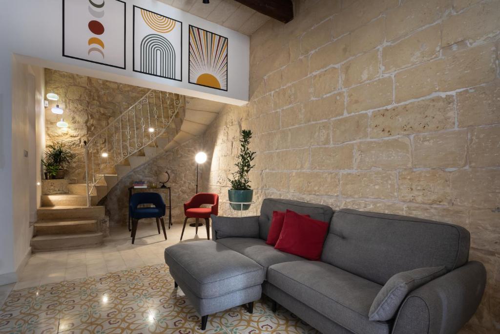 ŻejtunAuthentic Maltese 2-bedroom House with Terrace的带沙发和砖墙的客厅