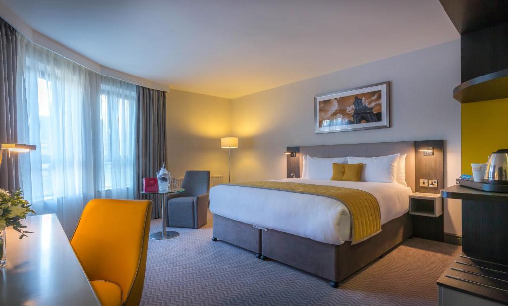 都柏林皮尔斯街马德龙酒店的酒店客房带一张大床和一把椅子