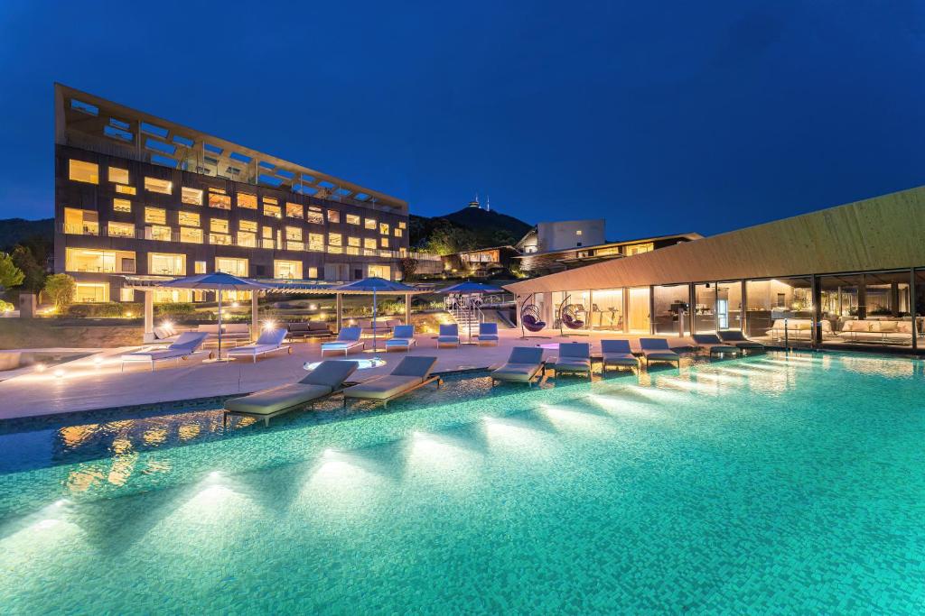 长崎长崎花园度假大酒店的一座带躺椅的游泳池和一座建筑