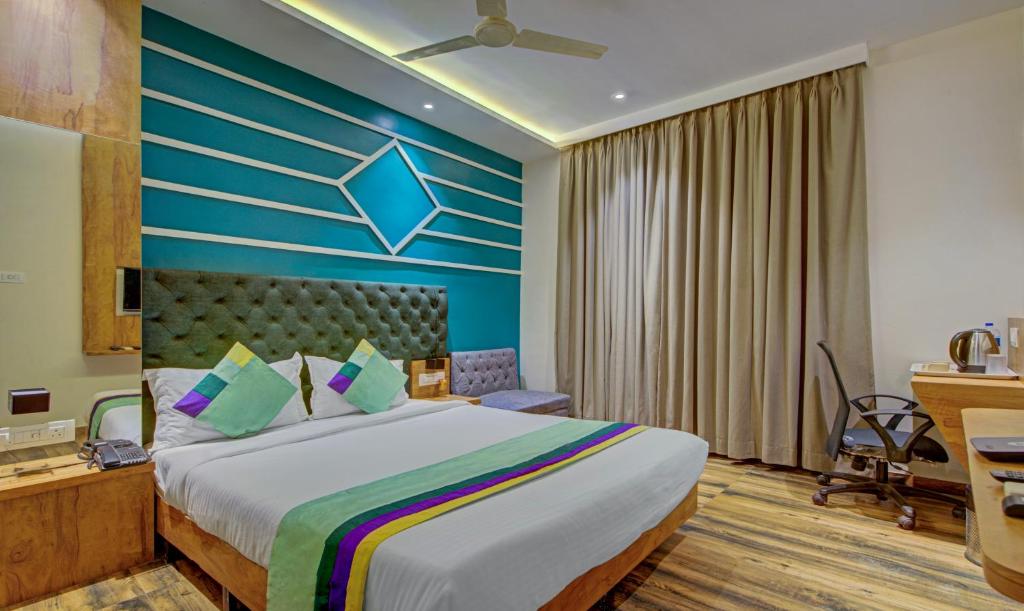 孟买Treebo Trend Prince, Mumbai的一间卧室设有一张蓝色墙壁的大床