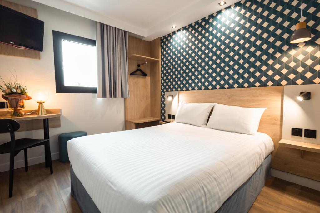 萨兰KYRIAD DIRECT ORLEANS NORD - Cap Saran的配有一张床和一张书桌的酒店客房