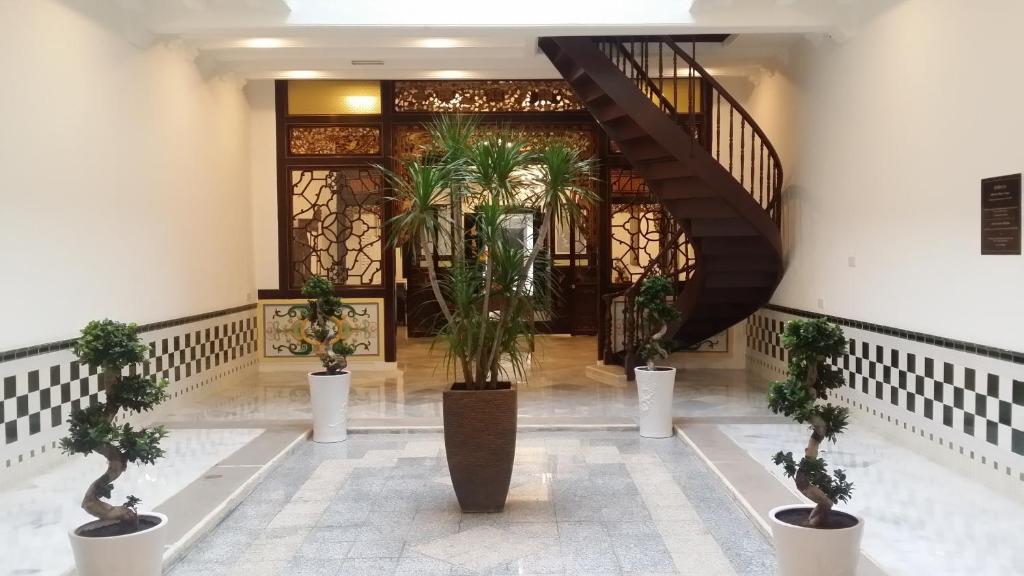 马六甲希伦棕榈套房酒店的大堂种植了盆栽植物,设有楼梯