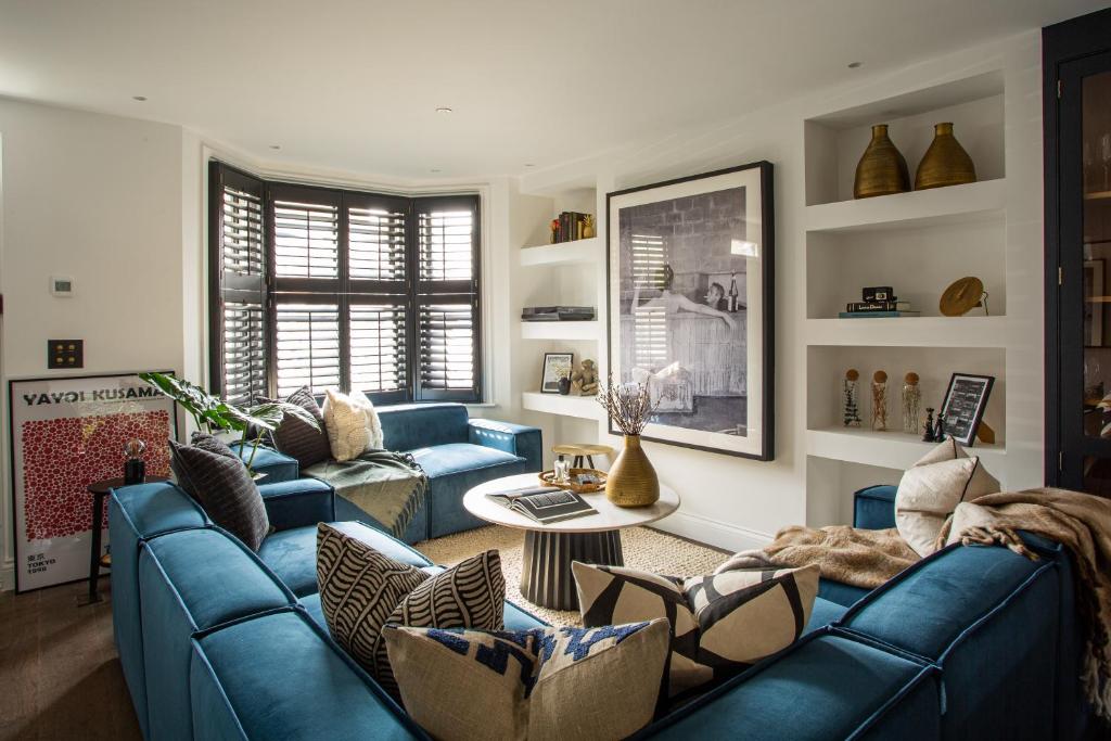 伦敦The Luxury Fulham Townhouse的客厅配有蓝色的沙发和桌子