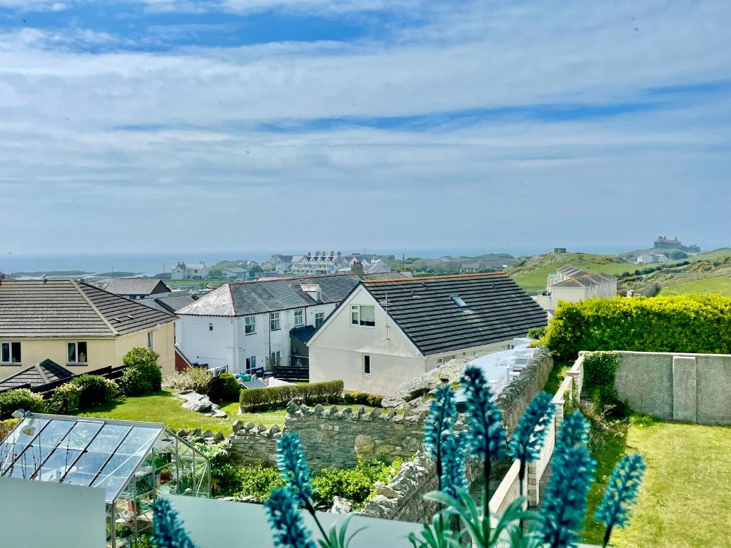 特雷杜尔Bay View Apartment - Trearddur Bay的享有郊区的房屋和蓝色鲜花的景色