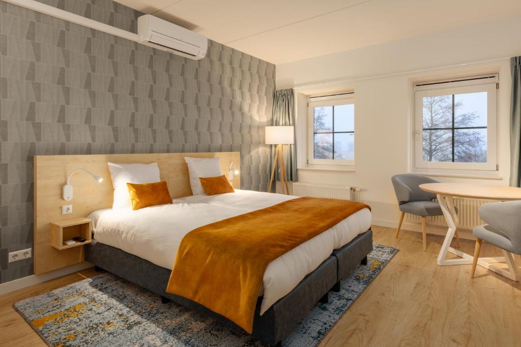 福伦丹Marinapark Volendam的酒店客房带一张床、一张桌子和椅子