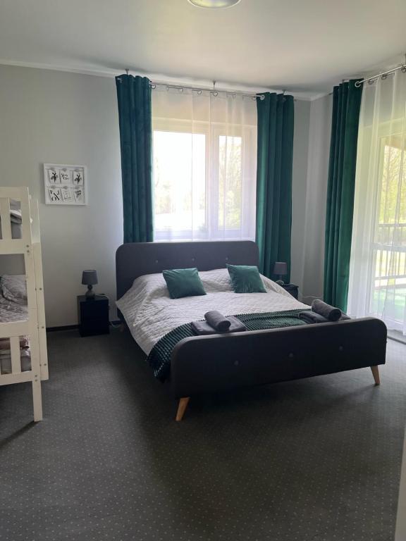 吉日茨科Camping Bystry的一间卧室配有一张带绿色窗帘的大床