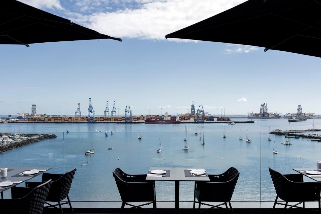 大加那利岛拉斯帕尔马斯Silken Saaj Las Palmas的享有海港的景色,在水中设有桌子和船只