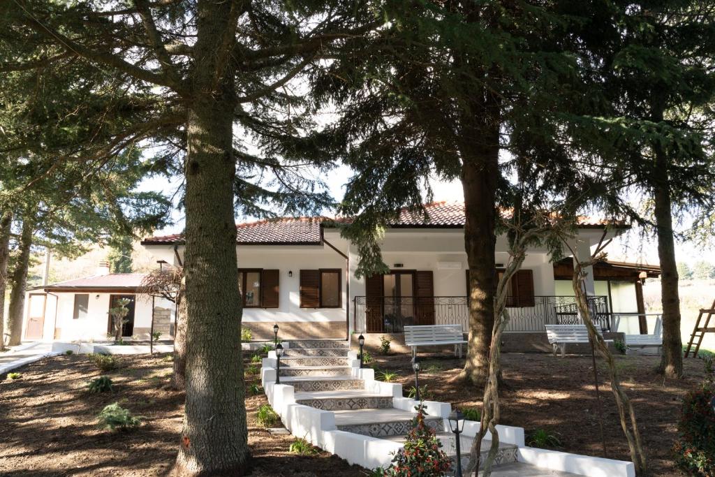 UcriaB&B Tenuta Piano Campo的前面有树木的白色房子