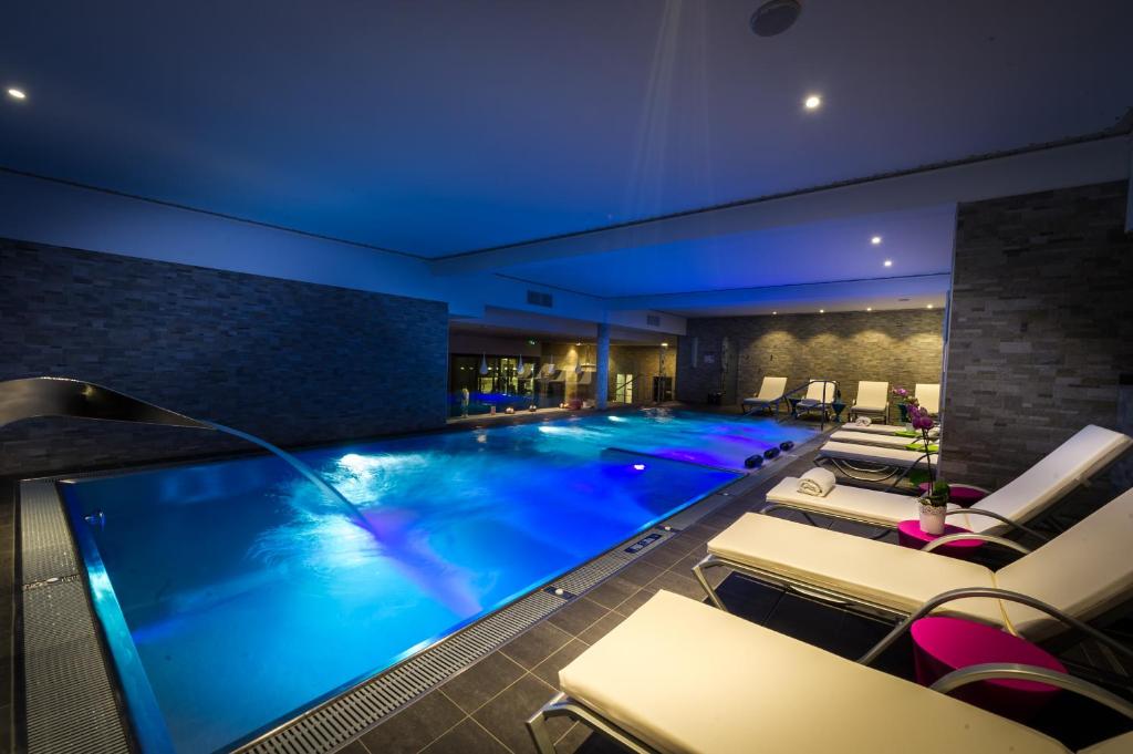 斯特拉斯堡Hôtel Restaurant Athena Spa的酒店的大型游泳池设有躺椅