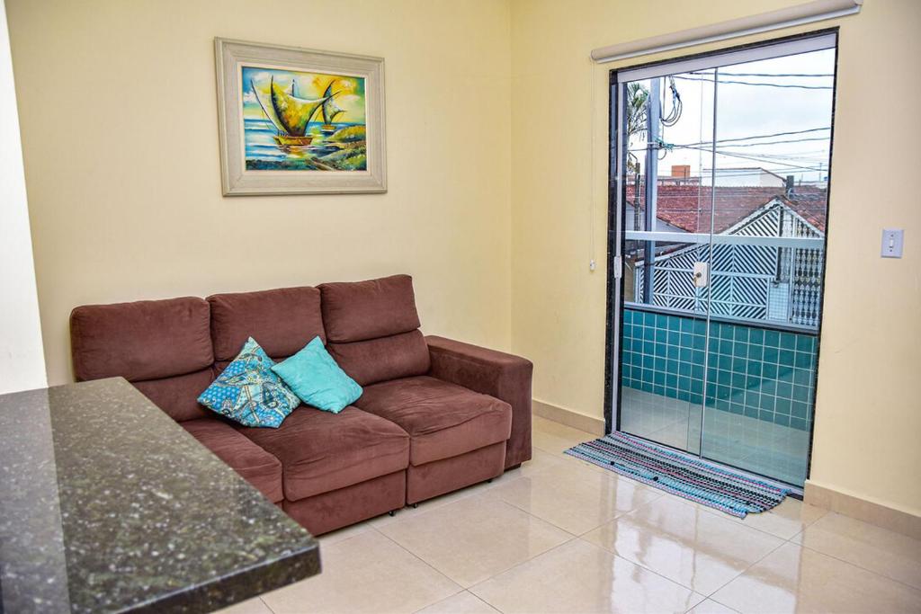 索莱马Casa com Wi-Fi a 400 metros da Praia Maracanã-SP的客厅设有棕色的沙发和窗户。