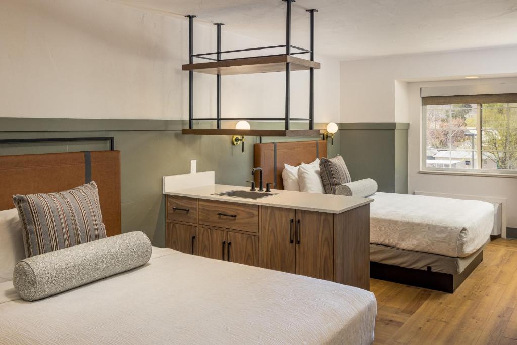 摩押河流大峡谷旅馆的一间卧室配有两张床、一个水槽和椅子