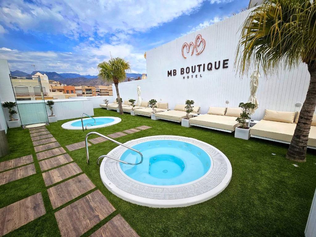 内尔哈MB Boutique Hotel - Adults Recommended的后院,草地上有一个大型游泳池