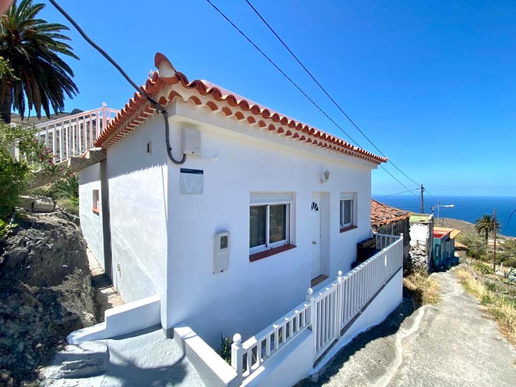 AlojeraCasa Los Palmeros Perdomo的一座白色的房子,背景是大海