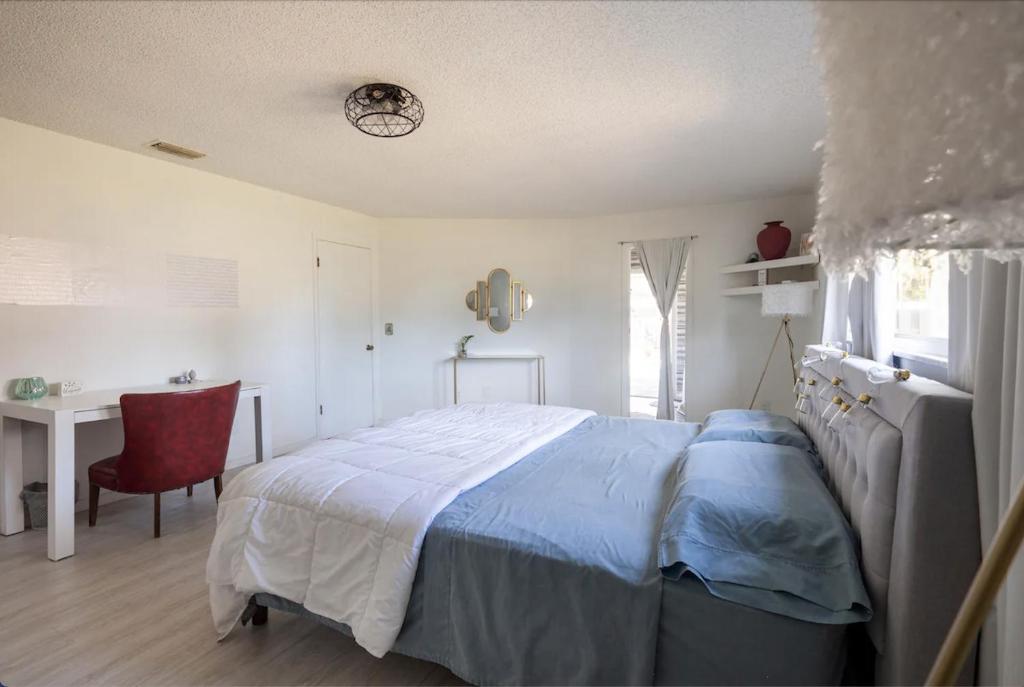 皮尔斯堡Serenity Studio的一间卧室配有一张床、一张书桌和一个窗户。