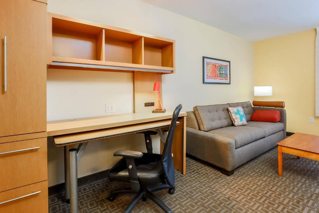 大学城TownePlace Suites by Marriott College Station的客厅配有书桌和沙发。
