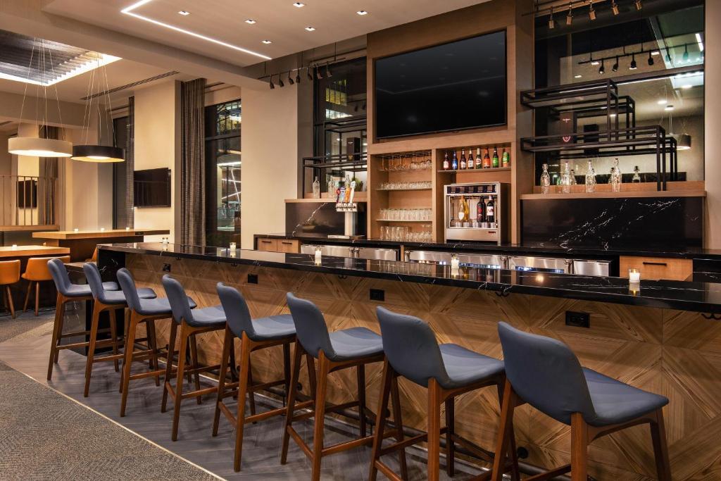 剑桥波士顿剑桥万豪原住客栈的餐厅内的酒吧设有椅子和电视