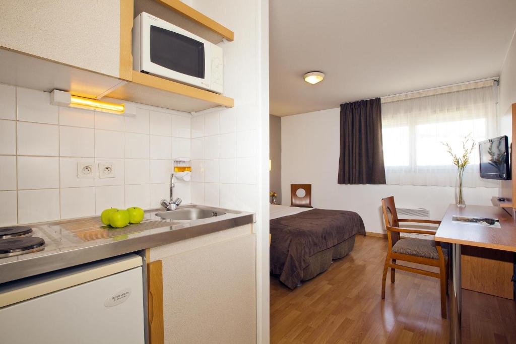 南特塞祖尔阿菲尔南特杜克布列塔尼酒店的带厨房的房间和一间带一张床的卧室