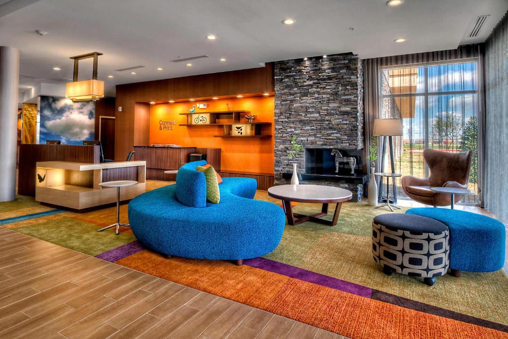 育空俄克拉荷马市育空费尔菲尔德套房酒店的大堂设有蓝色椅子和客厅。