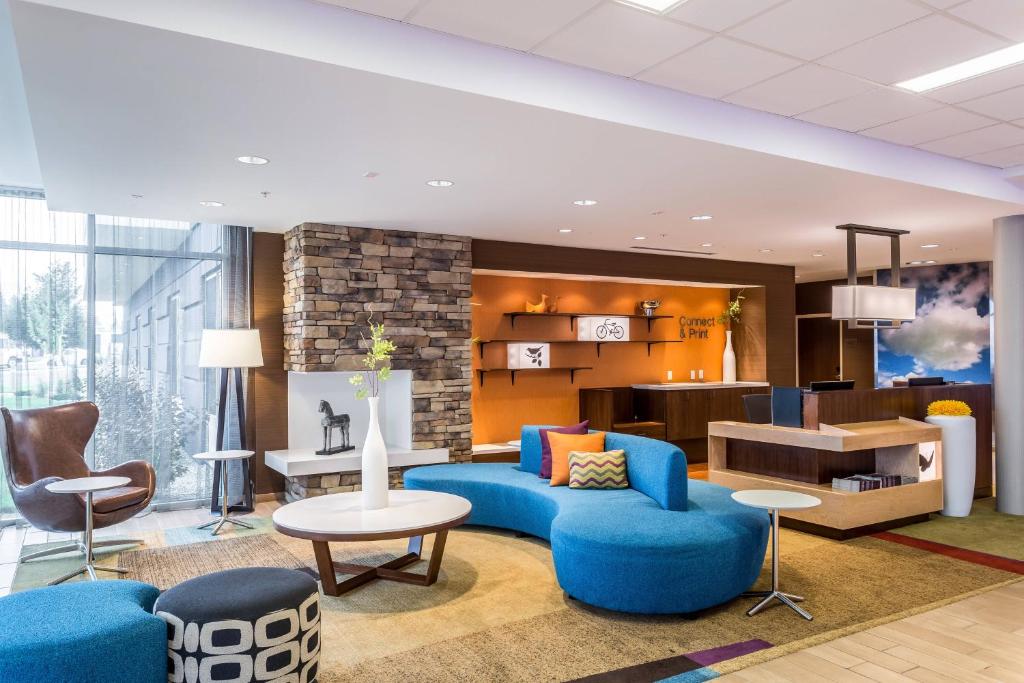 比尤特Fairfield Inn & Suites by Marriott Butte的大堂设有蓝色的沙发、椅子和桌子