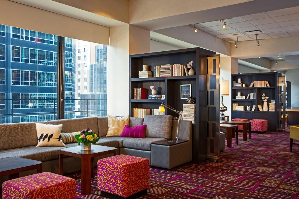 纽约纽约曼哈顿/市中心东区庭院酒店的大堂配有沙发和桌子,设有大窗户。