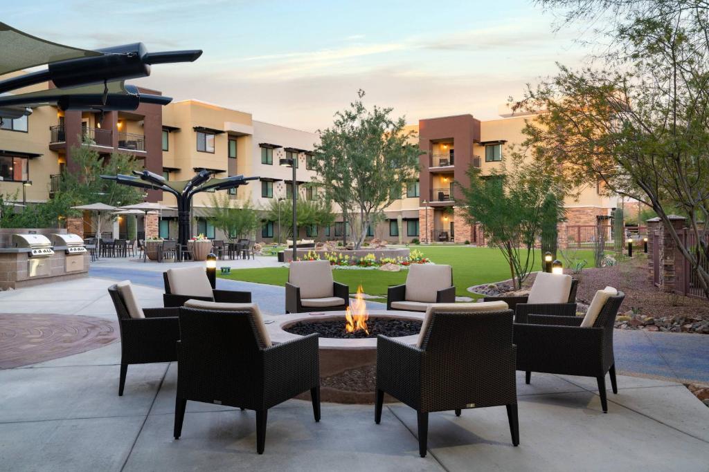 斯科茨Residence Inn by Marriott Scottsdale Salt River的庭院内带椅子和火坑的庭院