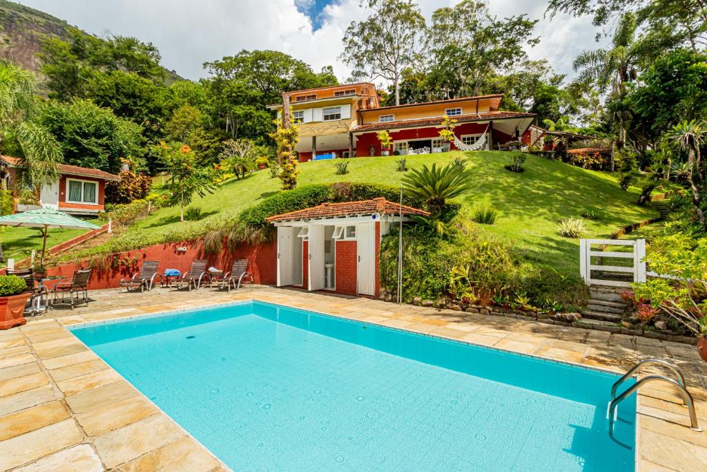 伊泰帕瓦Su Paradise Chalés e Suítes的房屋前有游泳池的房子