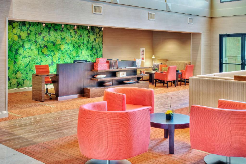 伊利伊利大使会议中心万怡酒店的大堂设有红色的桌椅和绿色的墙壁