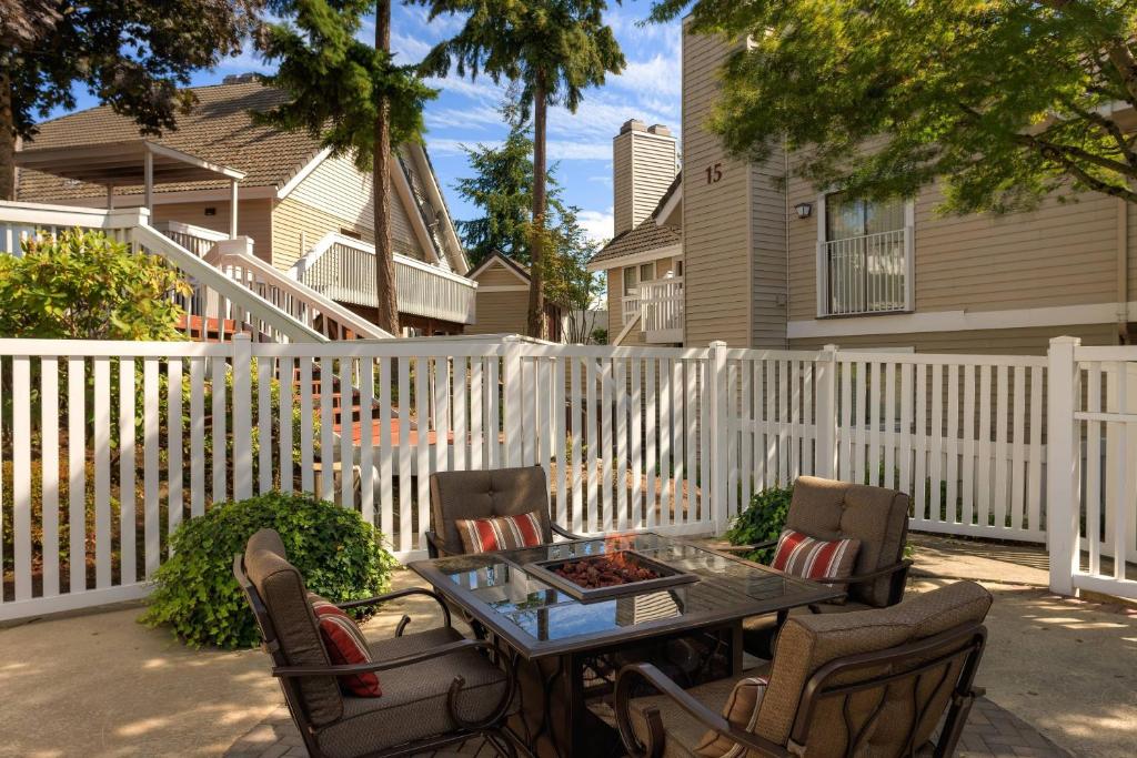 贝尔维尤Residence Inn by Marriott Seattle/Bellevue的一个带桌椅和围栏的庭院
