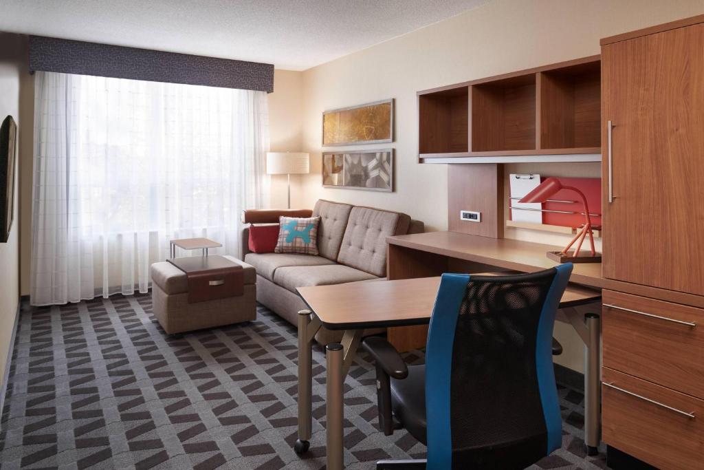 温莎温莎优质套房酒店的客厅配有沙发和桌子