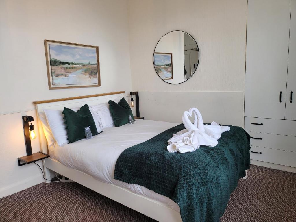 斯卡伯勒SeaView ground floor flat fast WiFi & FREE PARKING的一间卧室配有一张带绿毯和镜子的床