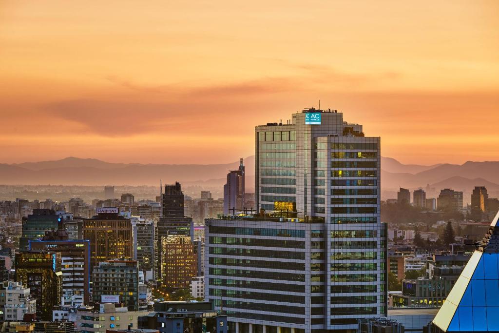 圣地亚哥AC Hotel by Marriott Santiago Costanera Center的日落时分享有城市天际线的景致