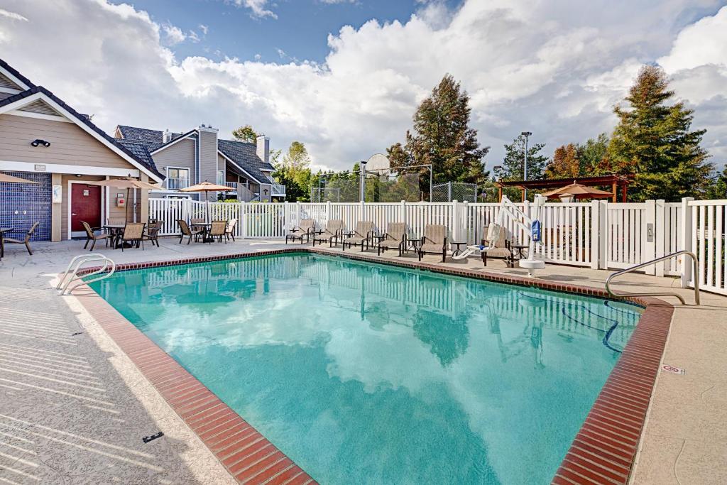 林伍德Residence Inn Seattle North/Lynnwood Everett的一个带椅子和围栏的游泳池