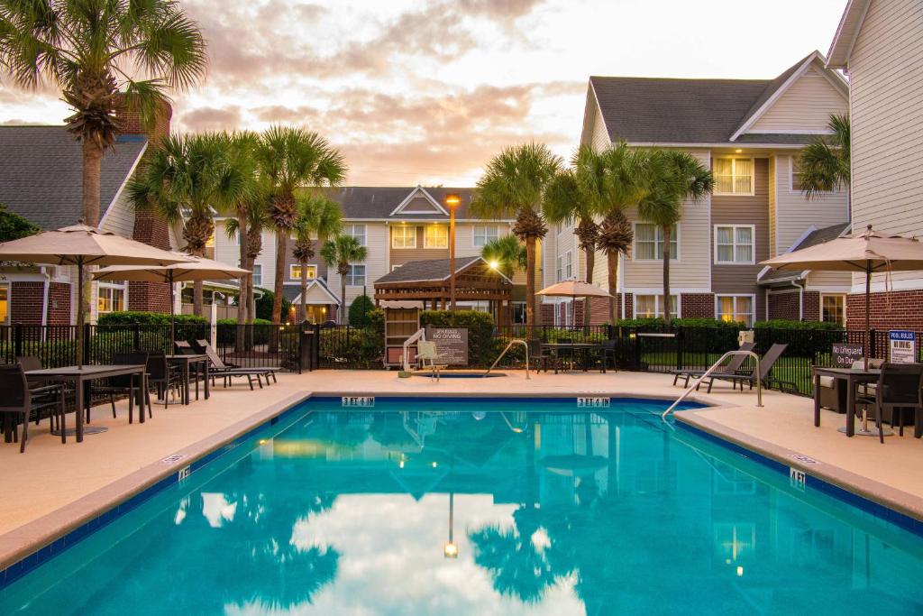 杰克逊维尔Residence Inn by Marriott Jacksonville Butler Boulevard的一个带桌椅的度假村游泳池