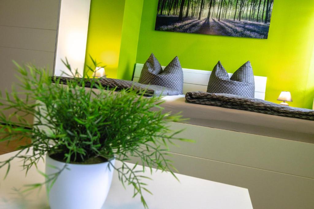 萨勒河畔瑙姆堡Pension Village的一间设有两张床的房间,桌子上放着盆栽植物