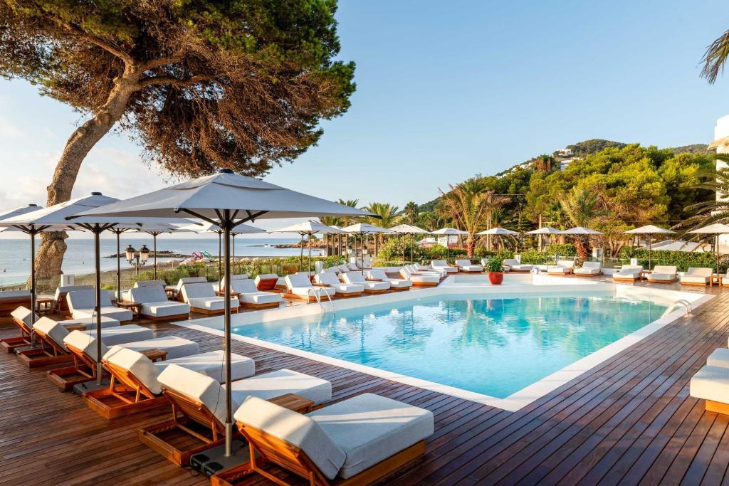 圣埃乌拉利亚Hotel Riomar, Ibiza, a Tribute Portfolio Hotel的一个带躺椅和遮阳伞的游泳池