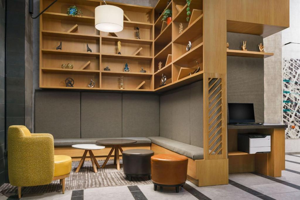 纽约TownePlace Suites by Marriott New York Manhattan/Chelsea的一间配有沙发、桌子和书架的客房