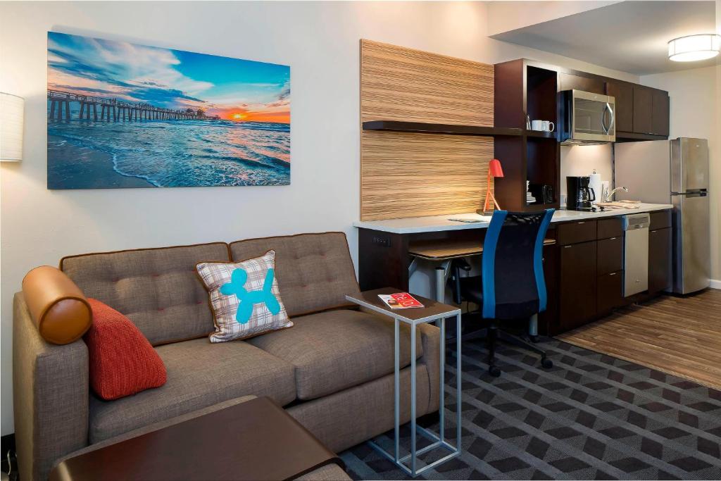 埃斯特罗TownePlace Suites by Marriott Fort Myers Estero的带沙发和书桌的客厅以及厨房。